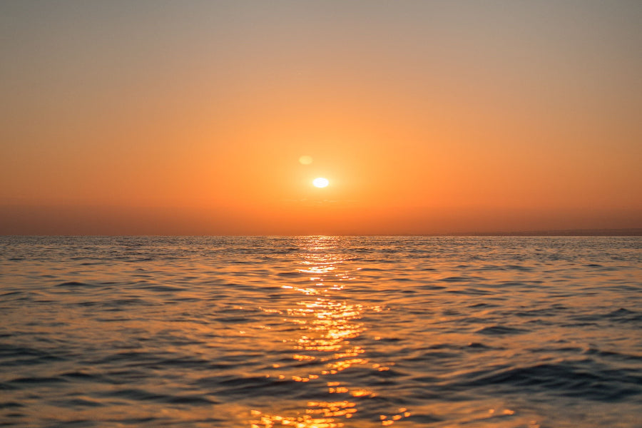 Sunset over the ocean with orange and blue colors.