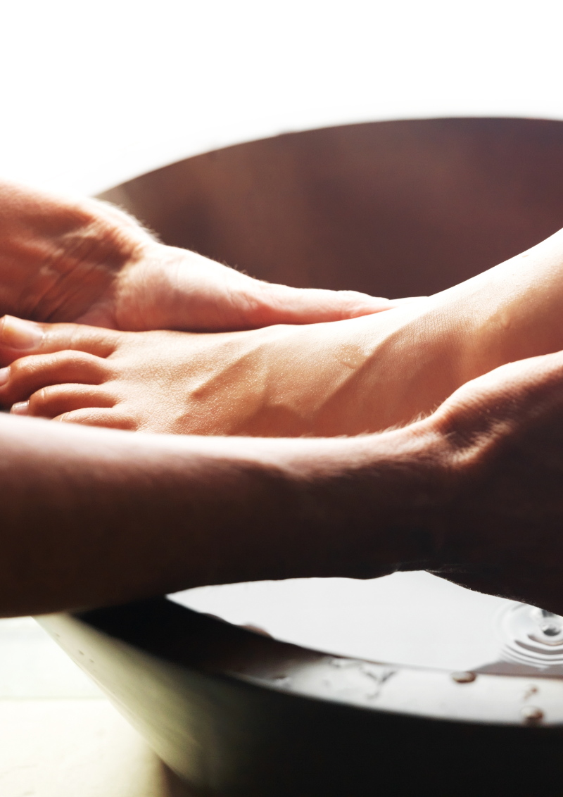 Close-up of a person's arm and hand resting on a wooden surface.