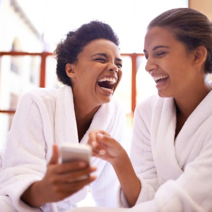 two robed women laughing in a spa